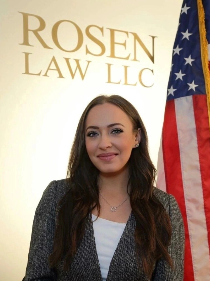 A woman standing in front of an american flag.