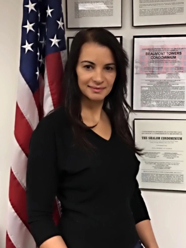 A woman standing in front of an american flag.