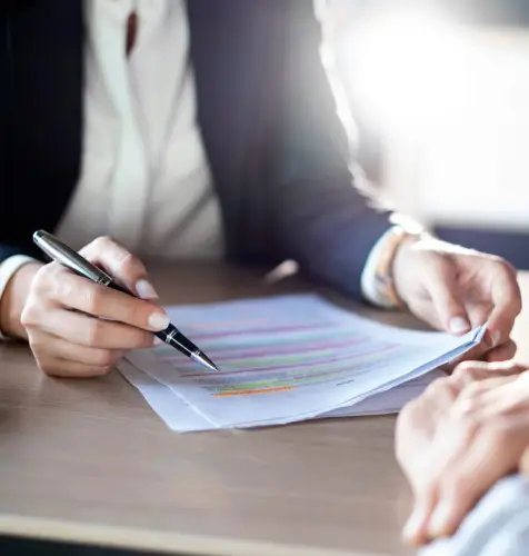 Person reviewing highlighted documents with pen